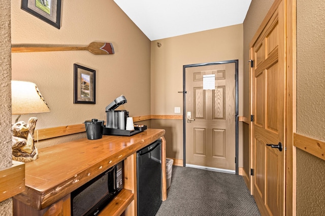 14125-307A Burlington Rd, Two Harbors, MN 55616 - home office with dark carpet, a textured wall, and lofted ceiling