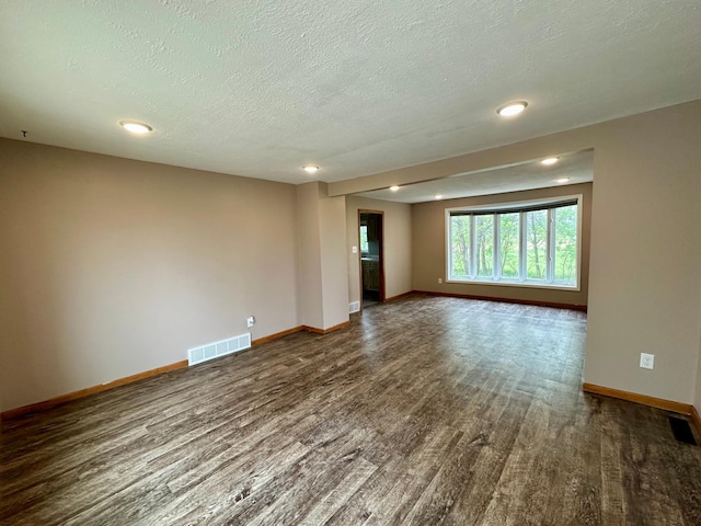 210 160th Ave, Osborne Twp, MN 56128 - empty room with dark wood-style flooring, baseboards, a textured ceiling, and recessed lighting