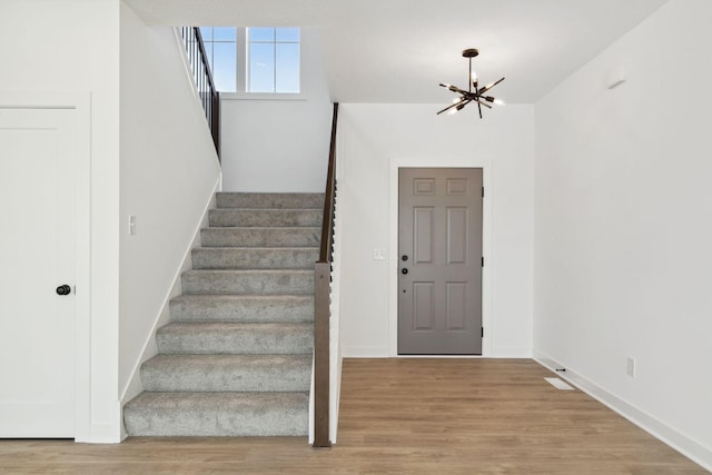 11781 34th St N, Lake Elmo, MN 55042 - stairway with a chandelier, wood finished floors, and baseboards