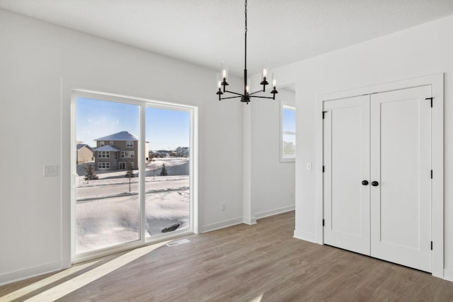 11781 34th St N, Lake Elmo, MN 55042 - dining space featuring wood finished floors, a chandelier, healthy amount of natural light, and baseboards