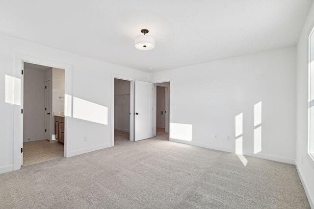 11781 34th St N, Lake Elmo, MN 55042 - unfurnished bedroom featuring light colored carpet, a spacious closet, and baseboards