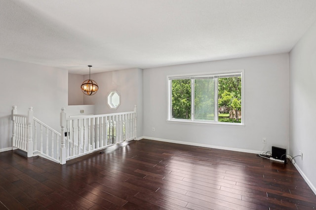 1650 132nd Ave NW, Coon Rapids, MN 55448 - spare room with a chandelier, wood-type flooring, and baseboards