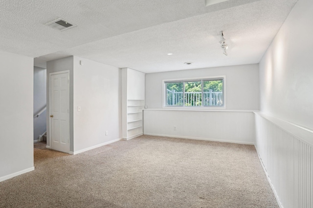 1650 132nd Ave NW, Coon Rapids, MN 55448 - carpeted empty room featuring a textured ceiling, baseboards, and track lighting