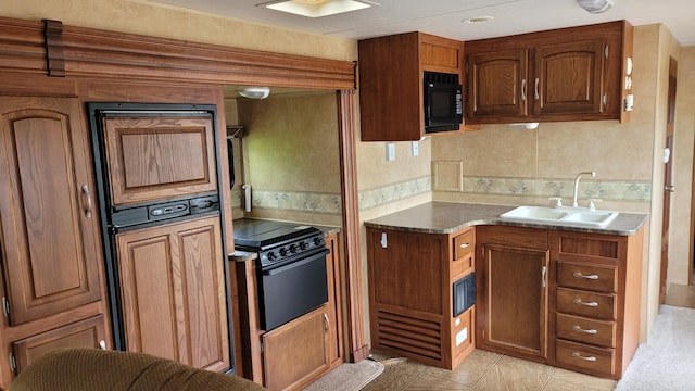 1101 Big Portage Lake Dr NW, Backus, MN 56435 - kitchen featuring a sink, black appliances, light tile patterned flooring, and brown cabinets