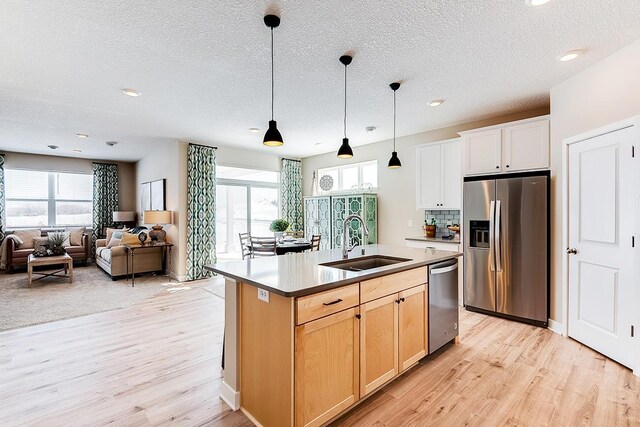 23683 Ashbury Dr, Rogers, MN 55374 - kitchen featuring appliances with stainless steel finishes, a sink, light wood-style flooring, plenty of natural light, and a textured ceiling