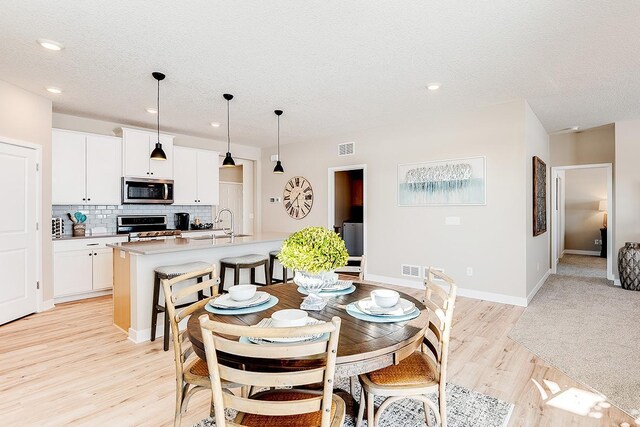 23683 Ashbury Dr, Rogers, MN 55374 - dining space with light wood-style floors, recessed lighting, a textured ceiling, and baseboards