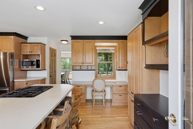 6185 Partridge Ct, Lino Lakes, MN 55110 - kitchen with appliances with stainless steel finishes, light wood-style flooring, a kitchen breakfast bar, light countertops, and recessed lighting