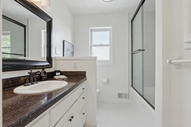 6185 Partridge Ct, Lino Lakes, MN 55110 - bathroom with vanity, toilet, tile patterned floors, shower / bath combination with glass door, and baseboards
