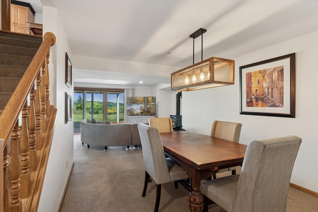 6185 Partridge Ct, Lino Lakes, MN 55110 - carpeted dining room featuring a wood stove, stairs, and baseboards