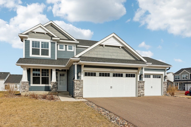 18378 Grasshopper Dr, Lakeville, MN 55044 - craftsman inspired home featuring stone siding, asphalt driveway, an attached garage, a porch, and a front yard