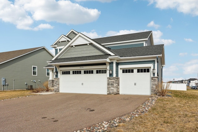 18378 Grasshopper Dr, Lakeville, MN 55044 - craftsman house with stone siding, asphalt driveway, an attached garage, and a shingled roof