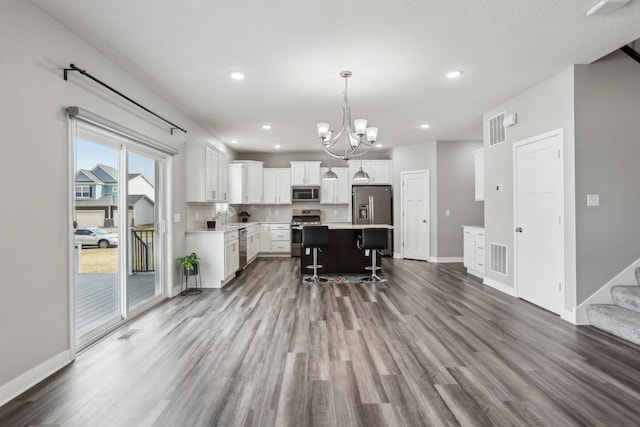 18378 Grasshopper Dr, Lakeville, MN 55044 - kitchen with stainless steel appliances, wood finished floors, a chandelier, a kitchen bar, and recessed lighting