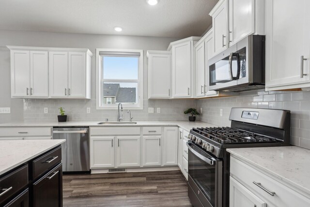 18378 Grasshopper Dr, Lakeville, MN 55044 - kitchen featuring appliances with stainless steel finishes, a sink, white cabinets, backsplash, and recessed lighting