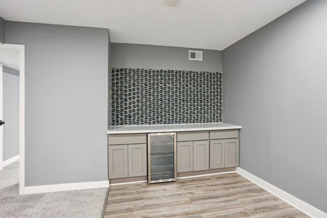 18378 Grasshopper Dr, Lakeville, MN 55044 - detailed view of wine cooler, wood finished floors, baseboards, and a dry bar