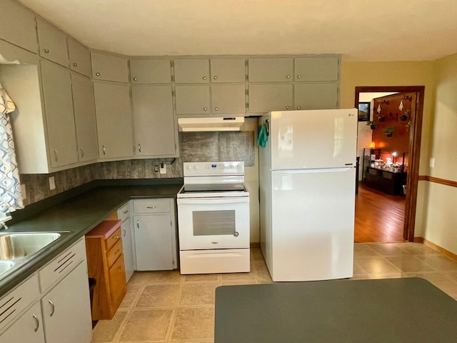 729 10th St E, Wabasha, MN 55981 - kitchen with white appliances, under cabinet range hood, dark countertops, and backsplash