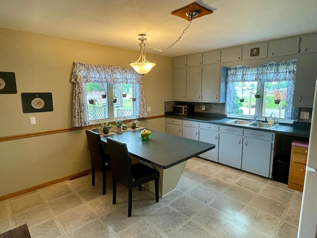 729 10th St E, Wabasha, MN 55981 - kitchen with a sink, dark countertops, stainless steel microwave, light floors, and baseboards