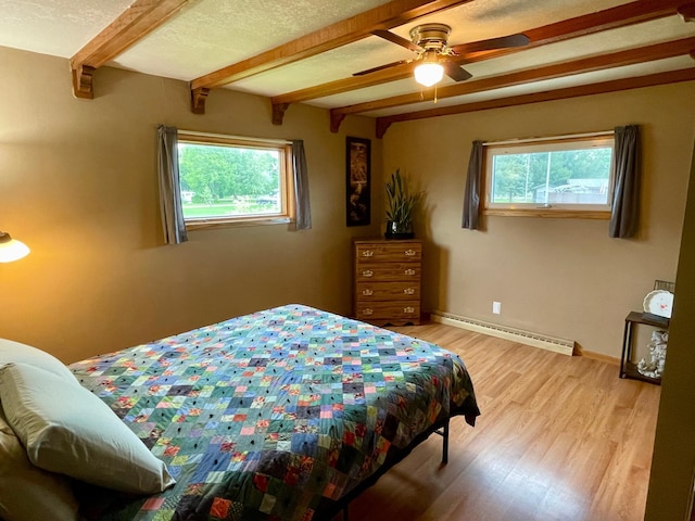 729 10th St E, Wabasha, MN 55981 - bedroom with a baseboard heating unit, beam ceiling, multiple windows, light wood finished floors, and baseboards