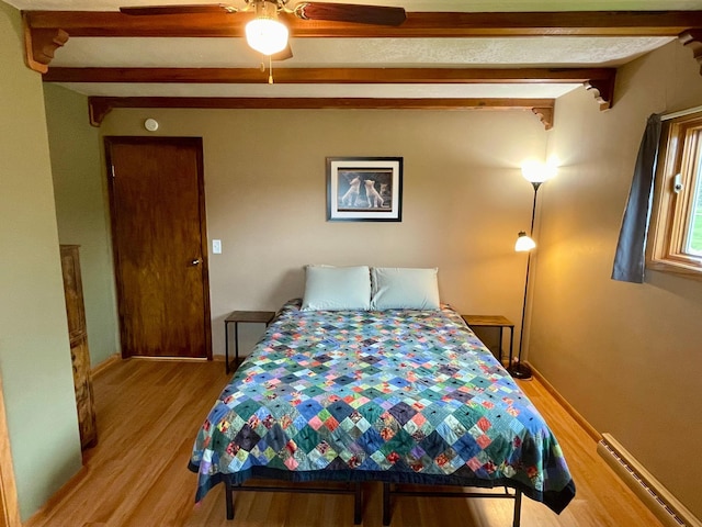 729 10th St E, Wabasha, MN 55981 - bedroom featuring a baseboard radiator, beam ceiling, light wood-type flooring, and a ceiling fan