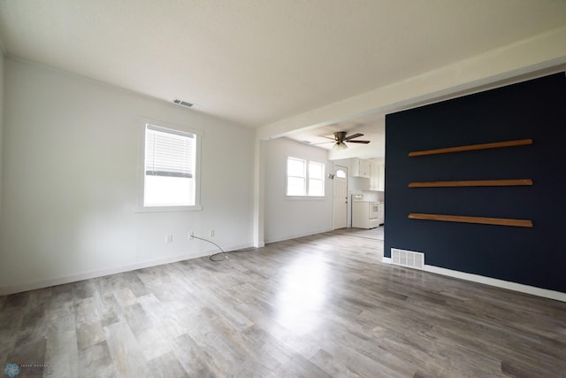 unfurnished living room with a ceiling fan, wood finished floors, and baseboards