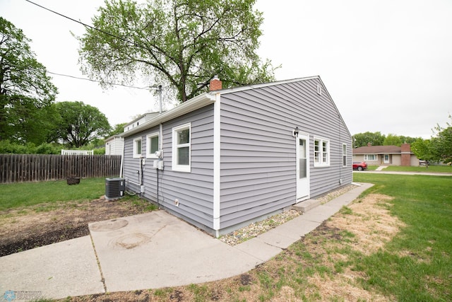 view of side of property featuring central AC, a patio, and a chimney