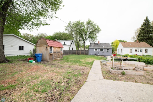 view of yard featuring a vegetable garden, a shed, and an outbuilding