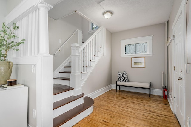 staircase with wood finished floors and baseboards