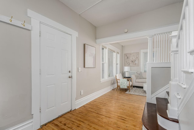 foyer entrance with light wood-style flooring and baseboards
