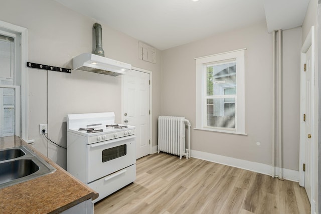 kitchen featuring radiator heating unit, white gas range, light wood finished floors, a sink, and exhaust hood