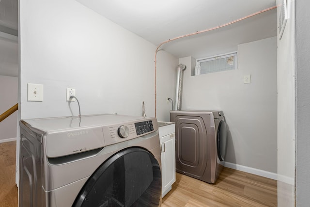 laundry area with washer and dryer, cabinet space, light wood-style floors, and baseboards
