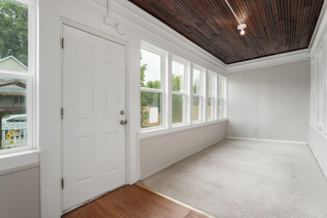 foyer entrance featuring wooden ceiling, carpet flooring, and baseboards