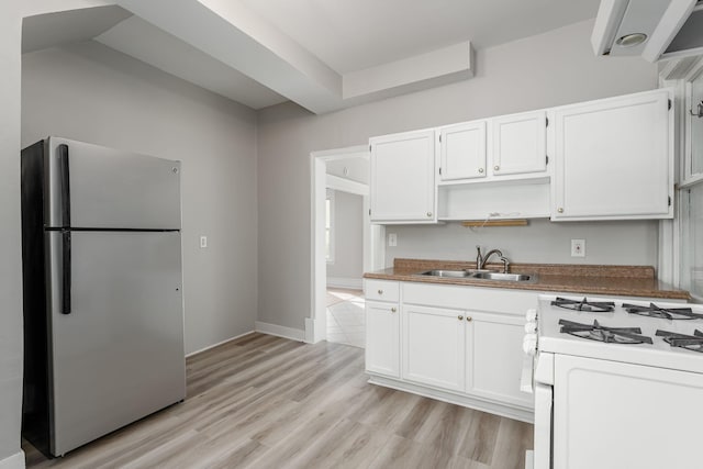 kitchen with freestanding refrigerator, a sink, white range with gas cooktop, open shelves, and white cabinets