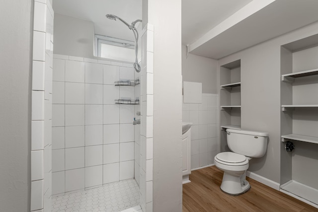 full bath with toilet, a tile shower, wood finished floors, and tile walls