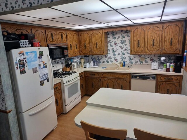 149 Riverview Dr Unit 5, Monticello, MN 55362 - kitchen with white appliances, brown cabinets, light countertops, a sink, and light wood-style flooring