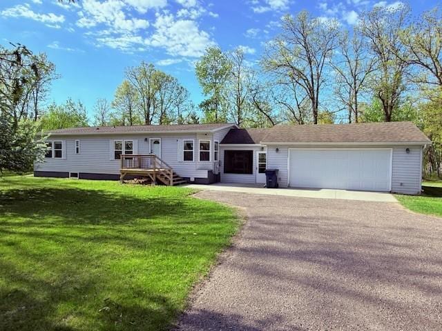 view of front of house featuring a front yard, an attached garage, and driveway