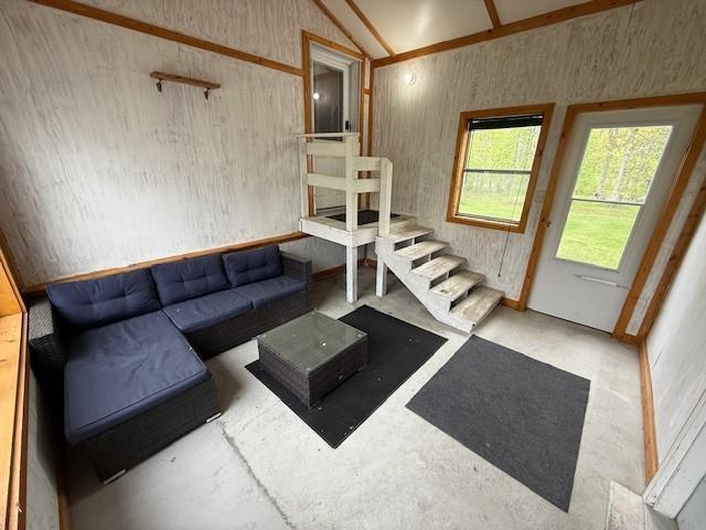 living area with lofted ceiling and concrete floors