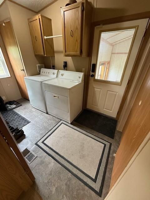 washroom featuring washing machine and clothes dryer and cabinet space