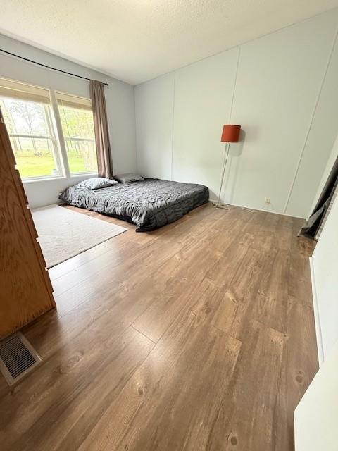 bedroom with wood finished floors and a textured ceiling