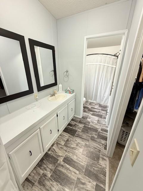 bathroom with vanity, a textured ceiling, toilet, and a shower with curtain