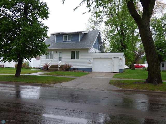 423 9th St N, Wahpeton, ND 58075 - view of front of home featuring driveway, a front yard, an attached garage, and roof with shingles