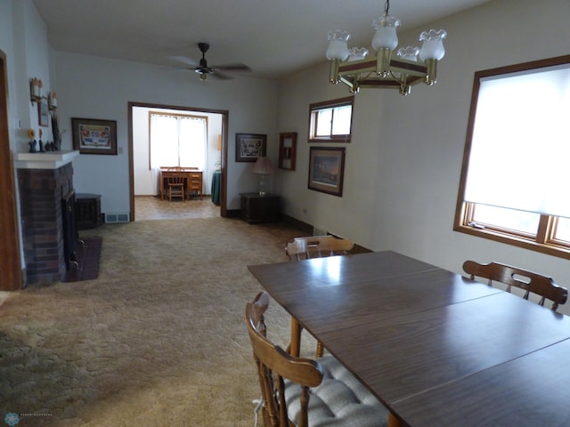 423 9th St N, Wahpeton, ND 58075 - dining room featuring a brick fireplace, ceiling fan, a chandelier, and carpet