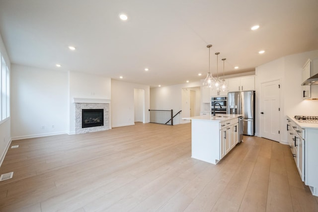11405 Fieldstone Dr, Rogers, MN 55311 - kitchen with stainless steel appliances, light countertops, recessed lighting, a center island with sink, and light wood-style floors