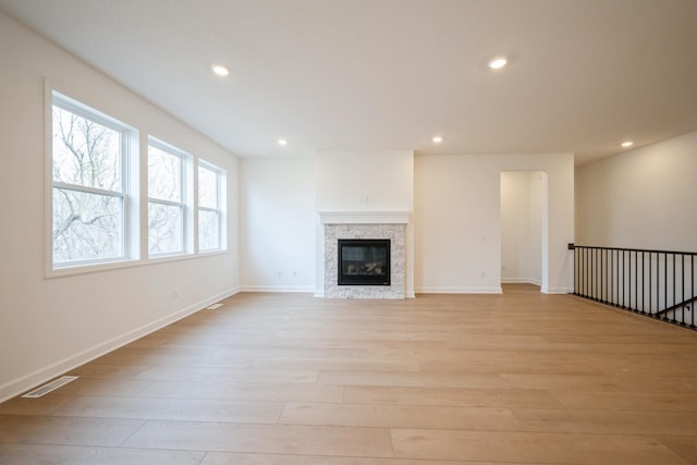 11405 Fieldstone Dr, Rogers, MN 55311 - unfurnished living room with light wood-type flooring, recessed lighting, baseboards, and a glass covered fireplace
