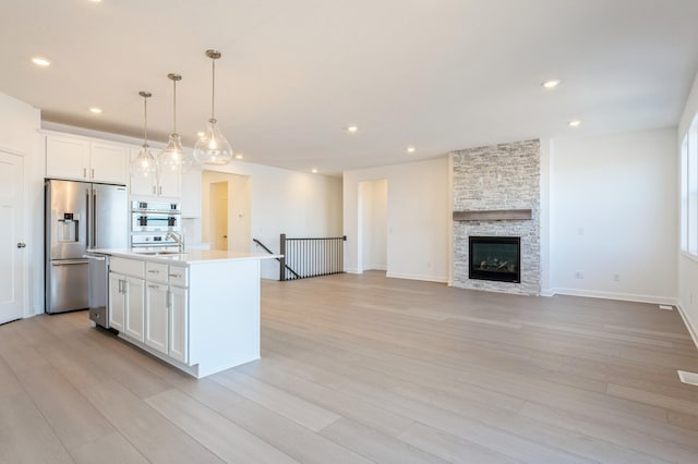 11405 Fieldstone Dr, Rogers, MN 55311 - kitchen with stainless steel appliances, white cabinetry, light wood-style floors, and recessed lighting