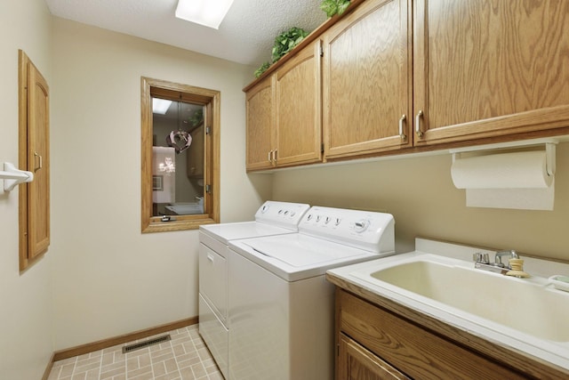 124 166th Ave NE, Andover, MN 55304 - washroom featuring washer and dryer, cabinet space, baseboards, and a textured ceiling