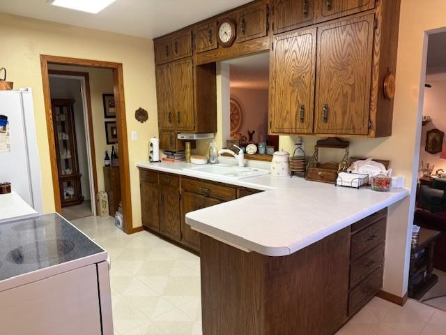 106 Morningside Rd, Albert Lea, MN 56007 - kitchen with a sink, range with electric cooktop, freestanding refrigerator, a peninsula, and light countertops