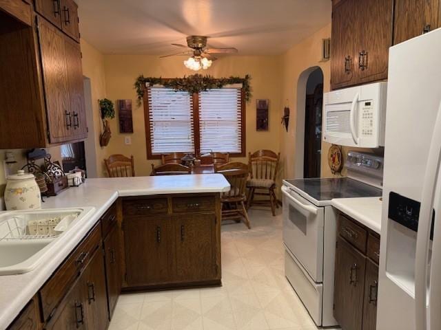 106 Morningside Rd, Albert Lea, MN 56007 - kitchen featuring white appliances, a ceiling fan, arched walkways, light floors, and light countertops