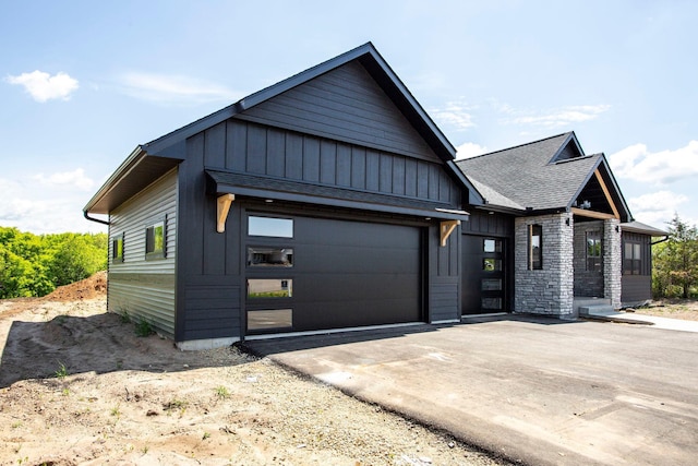 415 Moelter Ln, Troy Twp, WI 54016 - view of front of home with board and batten siding, concrete driveway, a garage, and a shingled roof