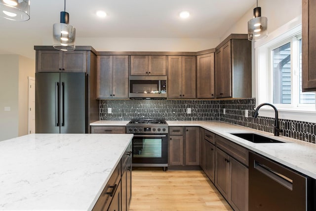 415 Moelter Ln, Troy Twp, WI 54016 - kitchen featuring appliances with stainless steel finishes, a sink, light stone countertops, light wood-style flooring, and backsplash