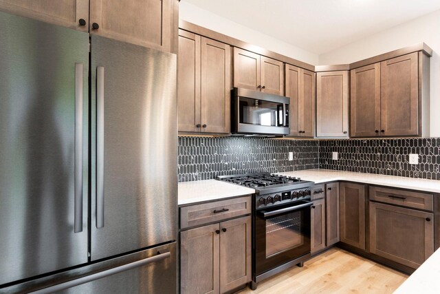 415 Moelter Ln, Troy Twp, WI 54016 - kitchen with stainless steel appliances, light countertops, light wood-style floors, and tasteful backsplash