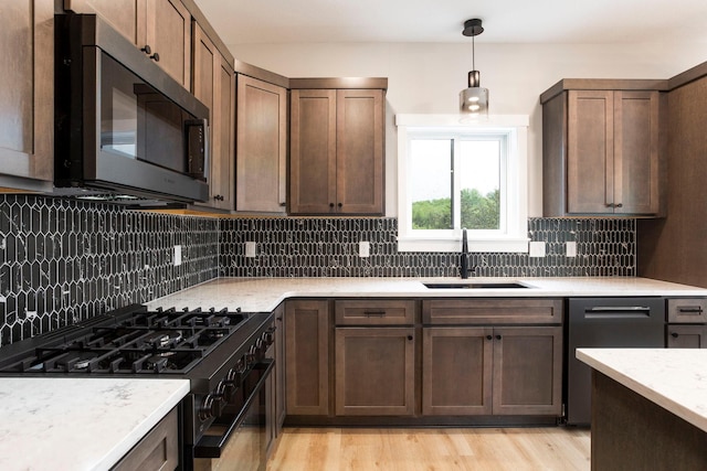 415 Moelter Ln, Troy Twp, WI 54016 - kitchen featuring appliances with stainless steel finishes, a sink, tasteful backsplash, and pendant lighting